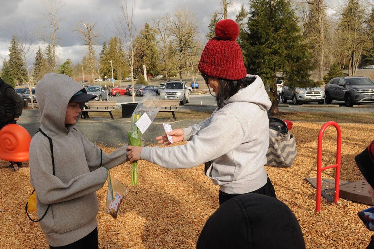 Rowan Sloan offers a stranger a bouquet of flowers.  (Jenna Hauck/The Chilliwack Progress/Handout)