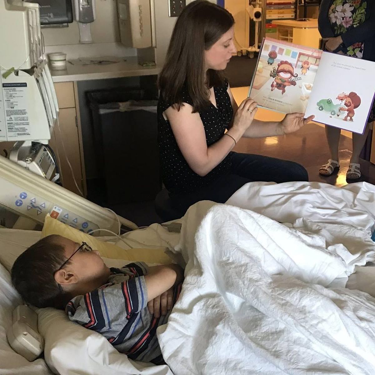 Library staffer Becky Mace reads to Kolton Anderson, 6. (Courtesy / Sacred Heart Children’s Hospital)