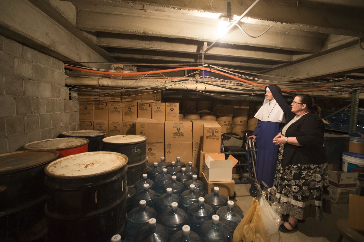 Above: Sister Mary Paula and school secretary Anne Marie Netzel examine the cramped, dusty basement of the Mount St. Michael convent and school in north Spokane on Thursday. (Jesse Tinsley)