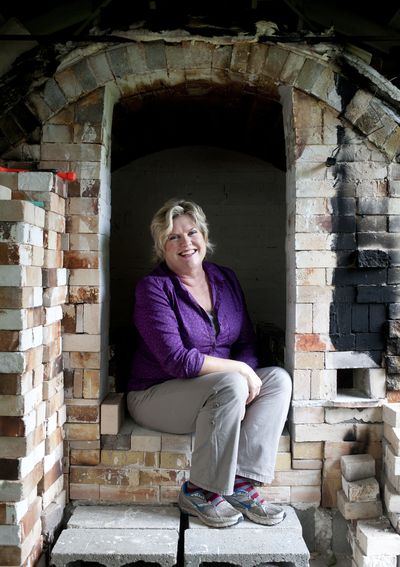 Gina Freuen poses for a photo in her kiln on Wednesday, at her home studio in north Spokane. Below, some of Freuen’s sculptures. Freuen’s studio will be open during the Little Spokane River Artist Studio Tour Sept. 28. (Tyler Tjomsland)
