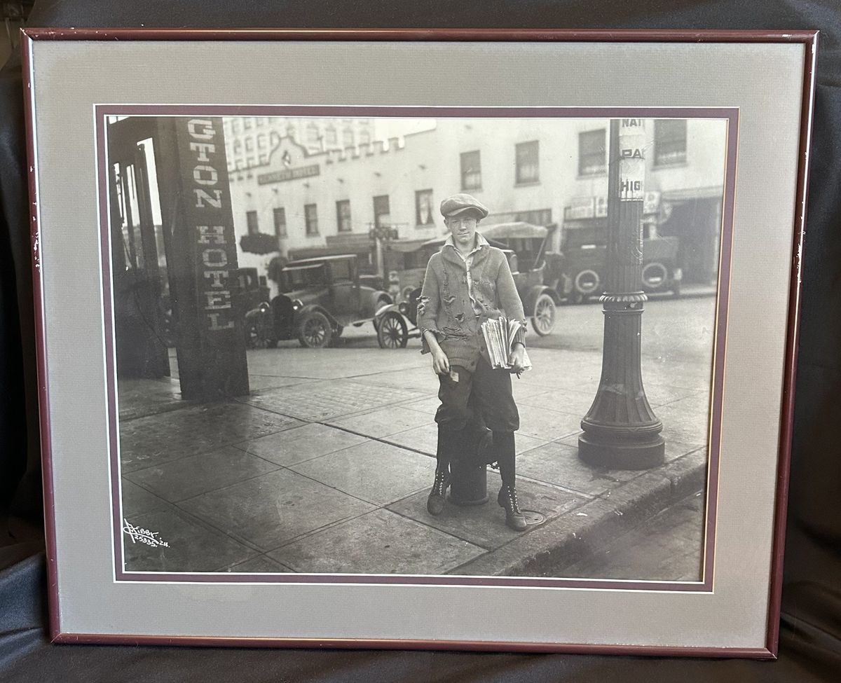 A 1920s-era newsboy clutches his stack of papers near a downtown Spokane street corner. The photo was originally captured by Charles A. Libby.  (Cynthia Reugh/For The Spokesman-Review)