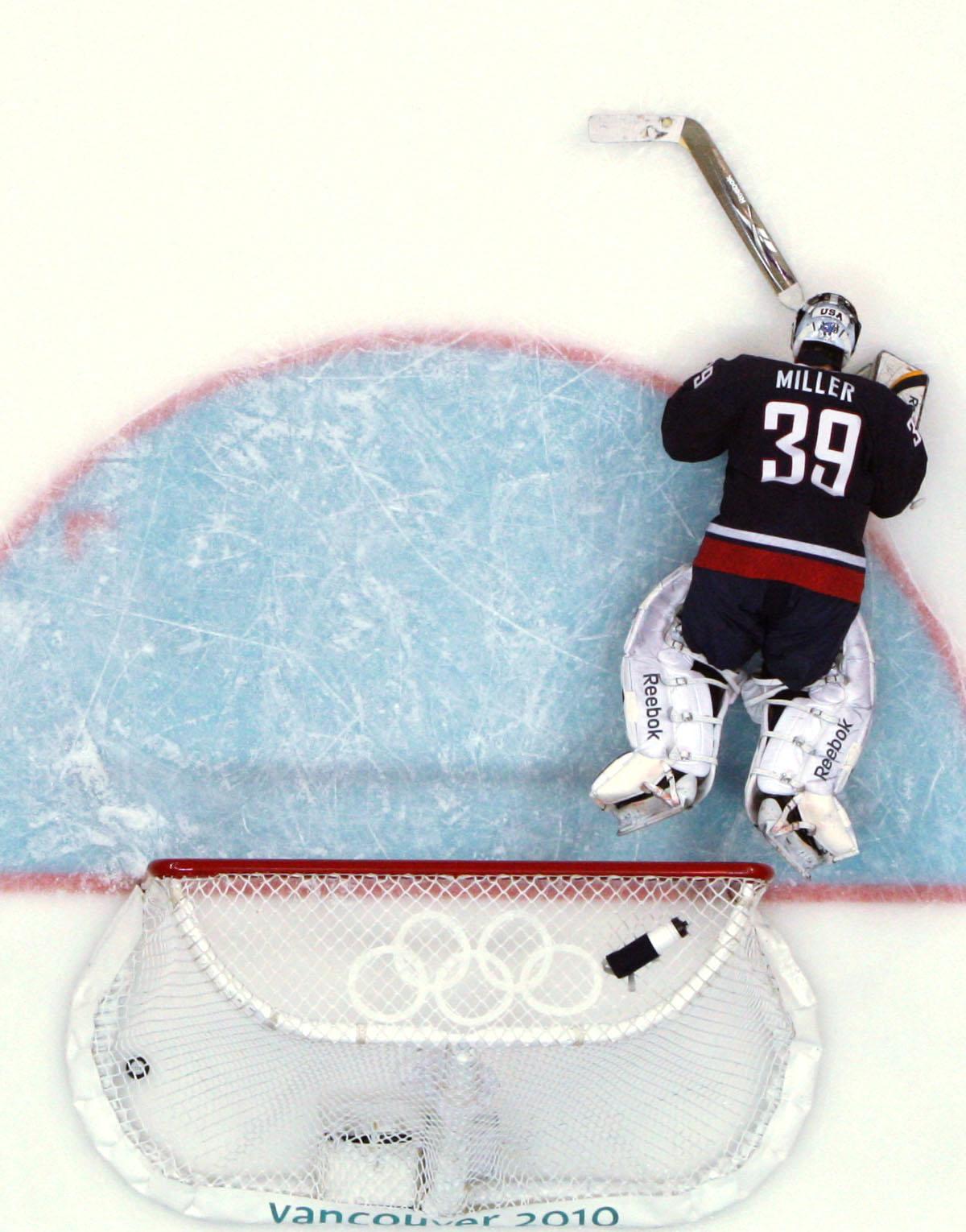 U.S. goalie Ryan Miller lays on the ice after Sidney Crosby’s overtime goal won the game and the gold for Canada. (Associated Press)