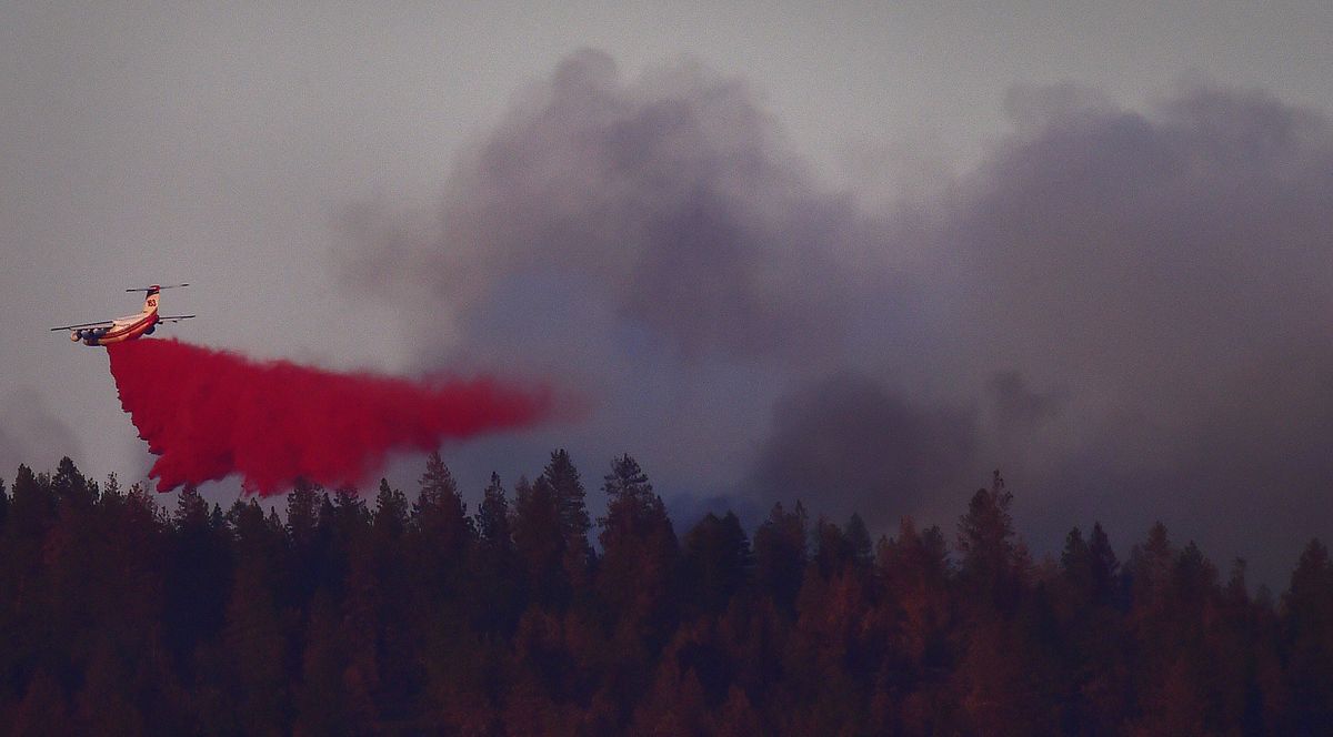 Planes drop fire retardant on the wildfire Tuesday near 4515 W. Country Hills Lane in Spokane. (Tyler Tjomsland)
