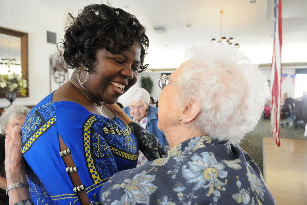 Elizabeth Koffi-Gue, left, hugs Bette McLuen, a resident of Orchard Crest Retirement Community, during a celebration Sept. 28 of Koffi-Gue’s recent naturalization. Koffi-Gue emigrated from Ghana in 2004 and has worked at Orchard Crest for several years.  (Jesse Tinsley)