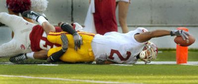 
USC's Steve Smith reaches for the goal line while being tackled by Husain Abdullah. 
 (Christopher Anderson / The Spokesman-Review)