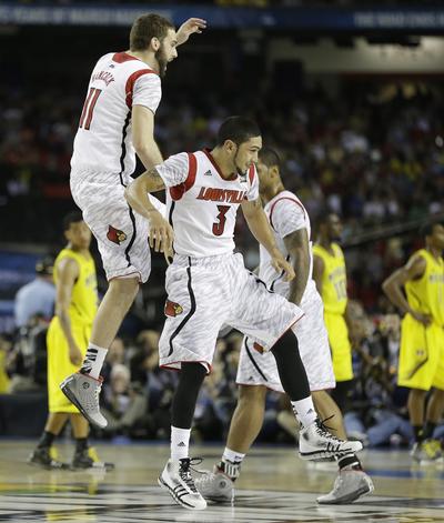 Louisville’s Luke Hancock, left, and Peyton Siva celebrate beating Michigan for the NCAA championship. (Associated Press)