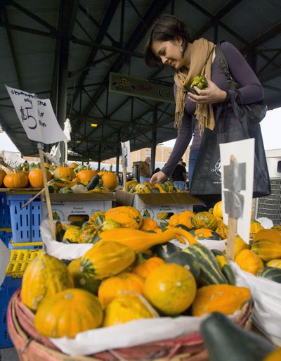 Carolyn Anderson picks out some ornamental gourds as she shops at The City Market on Saturday in Kansas City, Mo. A new report says sales of “local foods” amounted to $4.8 billion in 2008. (Associated Press)