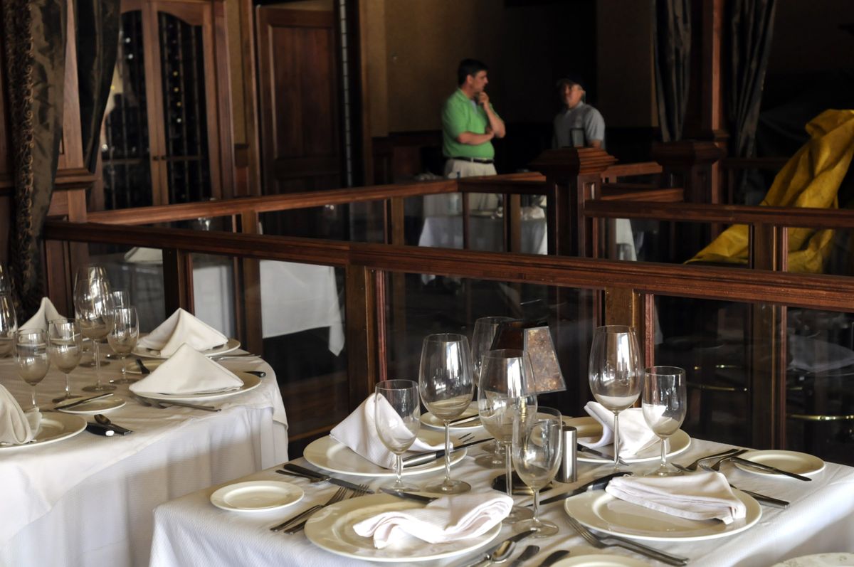 Bill Alles, left, an owner of Churchill’s Steakhouse, and adjuster Bruce Krager, of Farmers Insurance, discuss the damage inside the restaurant Friday afternoon, the day after a fire gutted the adjacent business in the Joel building. Churchill’s was saved from the flames, but sustained water damage. (Jesse Tinsley / The Spokesman-Review)