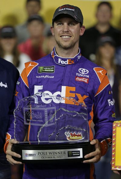 Denny Hamlin poses with the trophy in Victory Lane after winning the pole for Sunday's NASCAR Cup Series auto race at Charlotte Motor Speedway in Concord, N.C., Friday, Oct. 6, 2017. (Chuck Burton / Associated Press)