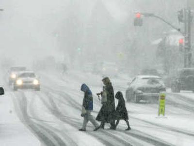 
Pedestrians brave blowing snow as they cross the main street of Chagrin Falls, Ohio, on Sunday. Associated Press
 (Associated Press / The Spokesman-Review)