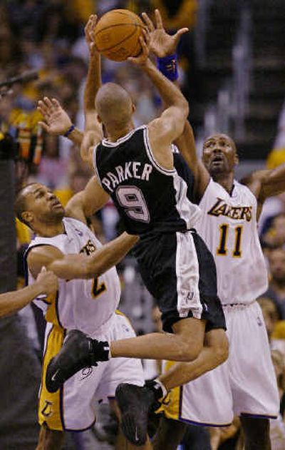 
Spurs' Tony Parker is double-teamed by Lakers defenders Derek Fisher, left, and Karl Malone as he attempts a shot. Spurs' Tony Parker is double-teamed by Lakers defenders Derek Fisher, left, and Karl Malone as he attempts a shot. 
 (Associated PressAssociated Press / The Spokesman-Review)