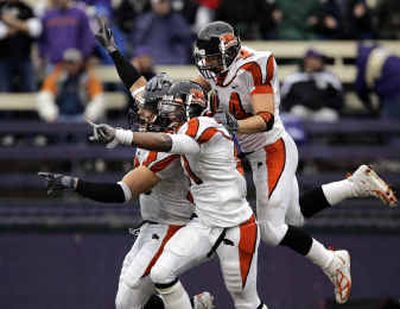 
Oregon State's Dallas Buck, left, Chaz Scott, center, and Pullman High grad Trent Bray whoop it up after Buck recovered a fourth-quarter fumble by turnover-plagued Washington. 
 (Associated Press / The Spokesman-Review)