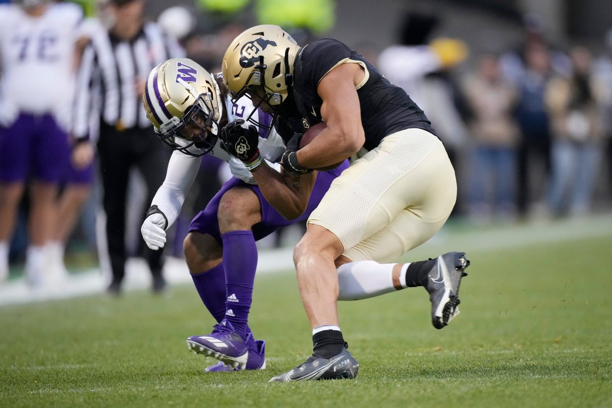 Washington defensive back Kyler Gordon, left, tackles Colorado wide receiver Daniel Arias after Arias pulled in a pass in the second half of an NCAA college football game Saturday, Nov. 20, 2021, in Boulder, Colo.   (Associated Press)