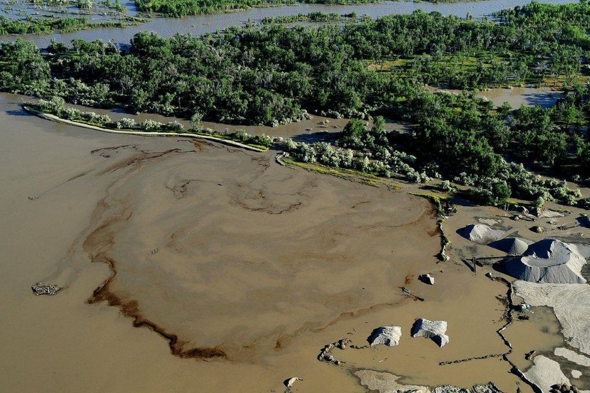 Oil swirls in a flooded gravel pit in Lockwood, Mont., after a pipeline break on July 2, 2011. (Associated Press)