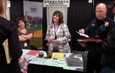 From left to right, Sarah Brooks, Christine Obleness and Sgt. David Window  talk to potential applicants Wednesday at the job fair's Washington state Department of Corrections booth.
 (Holly Pickett / The Spokesman-Review)