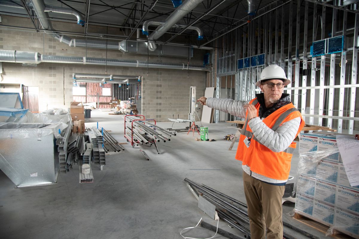 Greg Forsyth of Spokane Public Schools points the way to the fitness and weight room area of the new Flett Middle School which is taking shape the old parking lot of Joe Abli Stadium, shown Wednesday, March 30, 2022. The school is planned for a fall 2022 opening.  (Jesse Tinsley/THE SPOKESMAN-REVIEW)