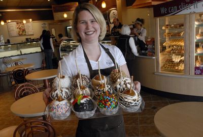 Owner Rachelle Blackmer shows off some of the signature Caramel Apples that are made and sold at  Rocky Moutain Chocolate Factory at 506 N. Sullivan Road in Veradale.  (J. BART RAYNIAK / The Spokesman-Review)
