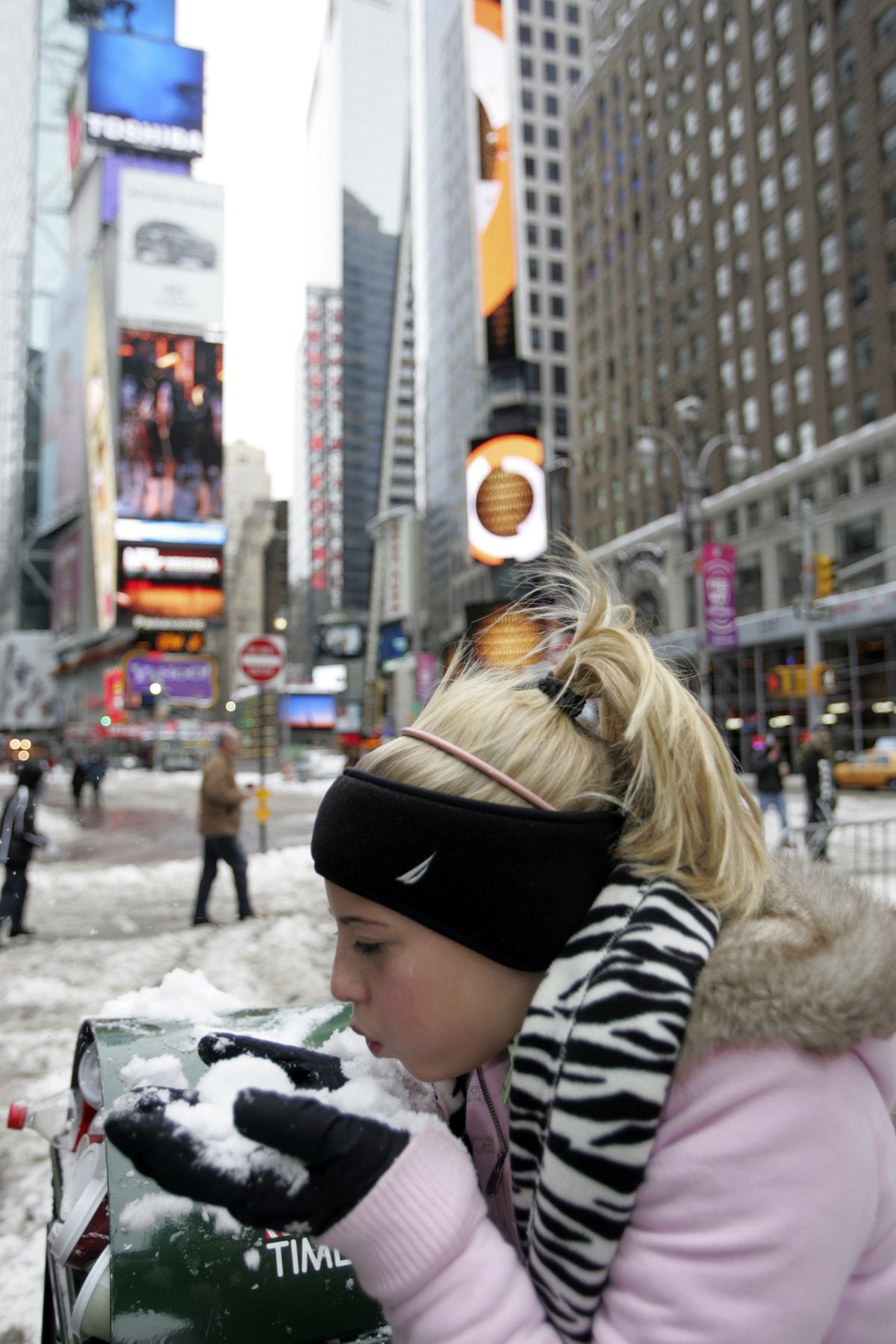 Morgan Rosbrook, 12, of Raleigh, N.C., blows snow from her hands Sunday in New York.