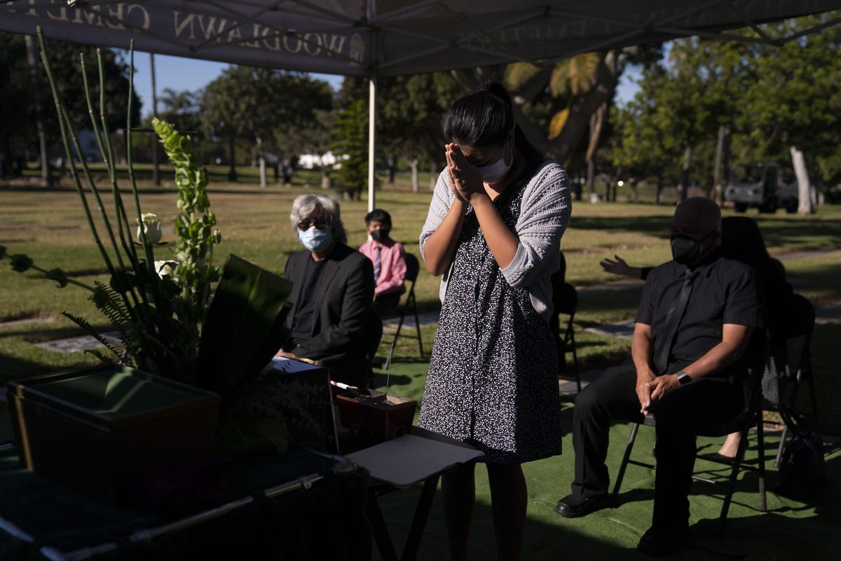 Lilah Matsumura, 11, prays for for her great-grandfather, Giichi Matsumura, during a memorial service at Woodlawn Cemetery in Santa Monica, Calif., Monday, Dec. 21, 2020. Giichi Matsumura, who died in the Sierra Nevada on a fishing trip while he was at the Japanese internment camp at Manzanar, was reburied in the same plot with his wife 75 years later after his remains were unearthed from a mountainside grave. (Jae C. Hong)