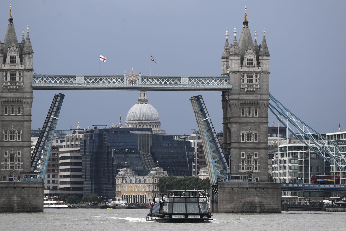 A boat sails down the River Thames in London, Monday Aug. 9, 2021 in front of Tower Bridge that is stuck in the fully open position due to a technical fault.  (Tony Hicks)
