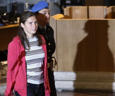 U.S. murder suspect Amanda Knox, left, is escorted by a penitentiary police officer as she arrives at Perugia's court, Italy, Saturday, Nov. 21, 2009. Prosecutors are set to make their sentencing requests for an American student and her former boyfriend accused of killing a British woman in Italy. (Alessandra Tarantino / Associated Press)