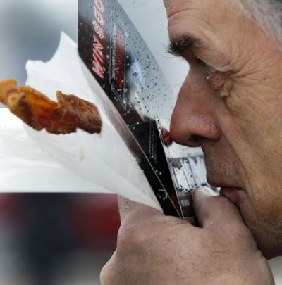 Dale Mottram takes a sniff of his scratch-and-sniff bacon-scented scratch ticket Friday at the welcome center in Hooksett, N.H. (Associated Press)