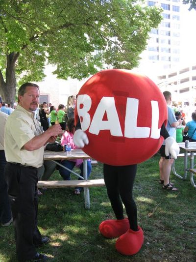 Norman Southworth, left, a sales representative for the Idaho Lottery in the Idaho Falls area, indulges in a free hot dog while chatting with the lottery's 