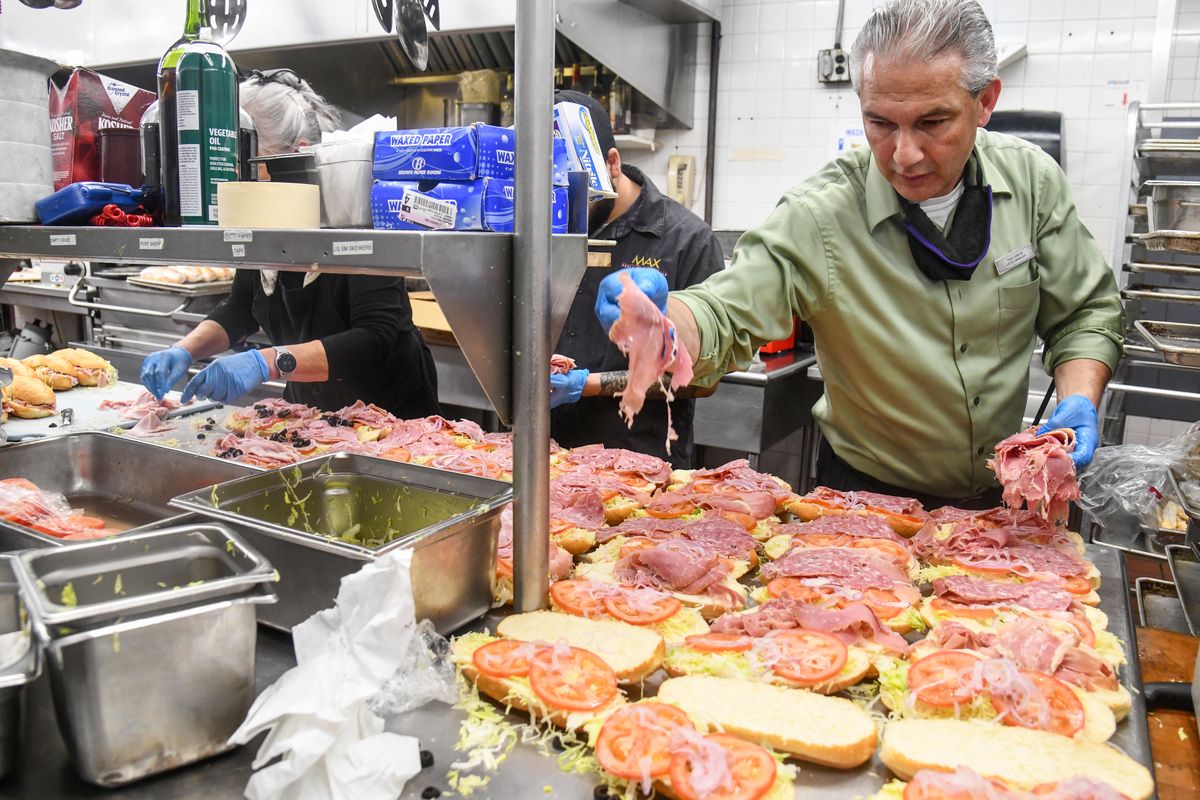 Mirabeau Park Hotel Assistant Manager Paul Santos, right, steps in to help make 105 sandwiches, Thursday, July 1, 2021, Santo was assisting in the kitchen due to a shortage of workers.  (Dan Pelle/THE SPOKESMAN-REVIEW)