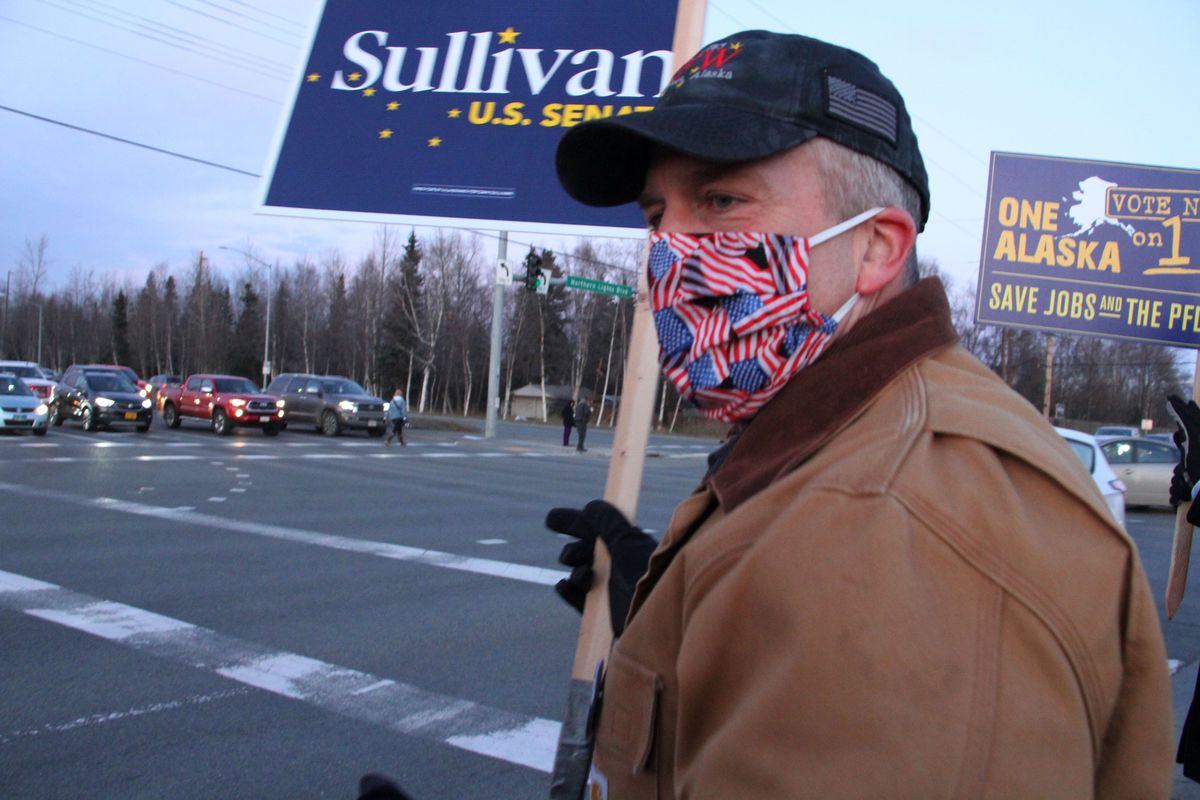 FILE - In this Nov. 2, 2020, file photo, Republican U.S. Sen. Dan Sullivan waves a sign at a busy intersection in Anchorage, Alaska. Sen. Sullivan on Wednesday, Nov. 11, 2020, won re-election in Alaska, defeating independent Al Gross.  (Mark Thiessen)