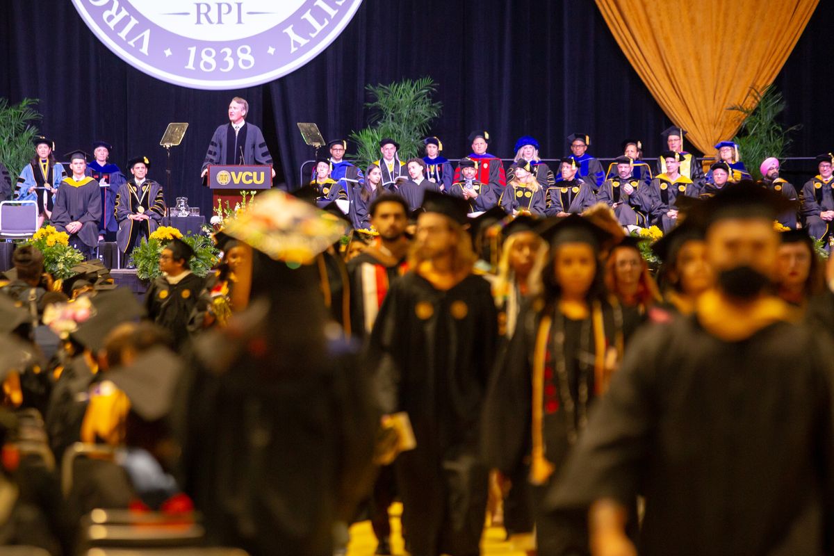 Dozens of Virginia Commonwealth University students walk out of the auditorium as Gov. Glenn Youngkin (R-Va.) gives the commencement address in Richmond on Saturday.  (Parker Michels-Boyce/For The Washington Post)