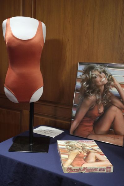Objects from the private collection of Farrah Fawcett's estate, including the red swimsuit from her iconic 1976 poster, right, are seen at the Smithsonian's National Museum of American History, in Washington, Wednesday, Feb. 2, 2011, where they were donated. (Jacquelyn Martin / Associated Press)