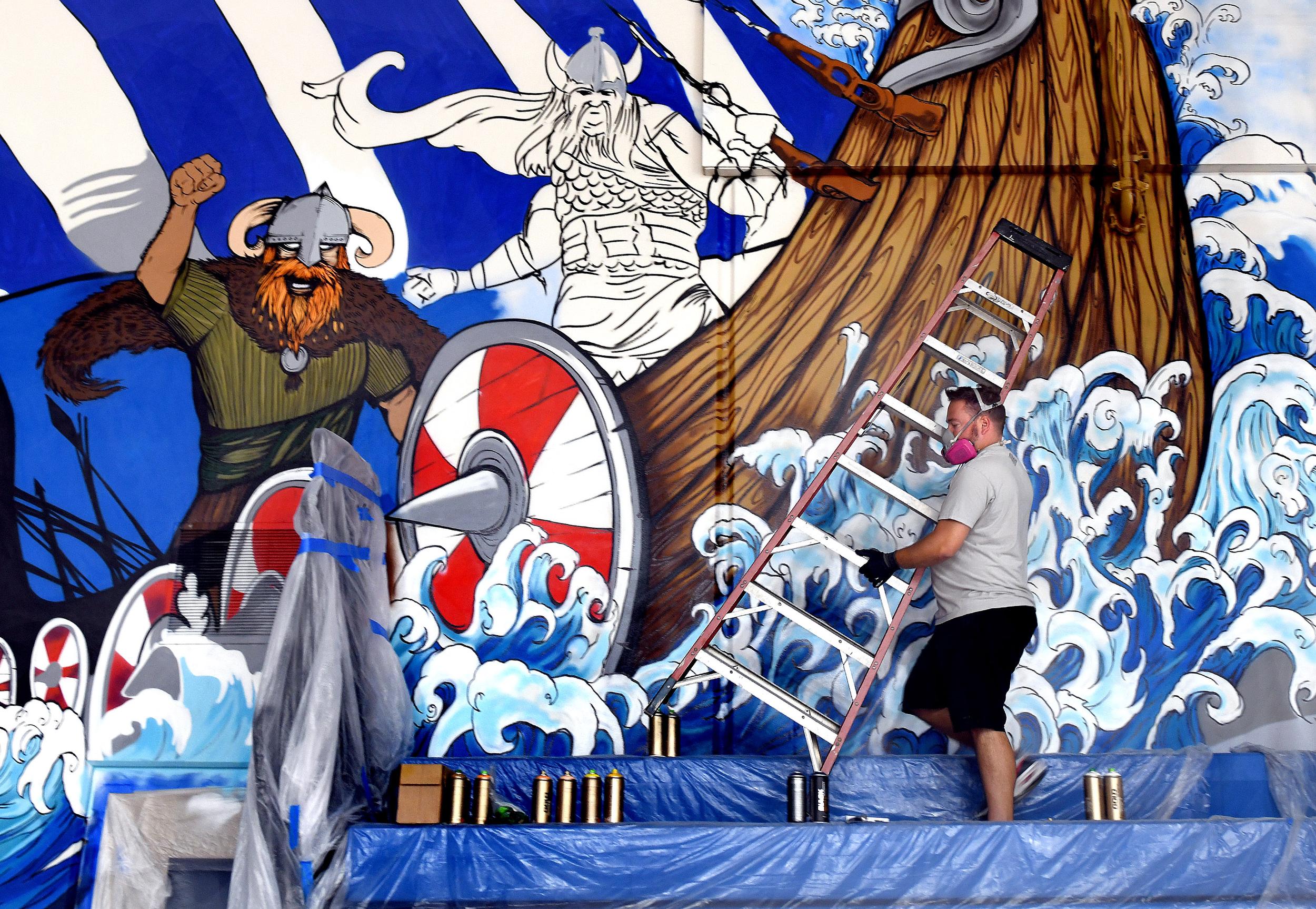 Two local artists lift school spirit with colorful murals