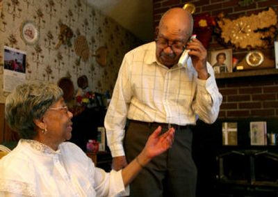 
Elneda Mallory reaches for the phone from her husband, Al, so she can speak to her brother Richard Robinson    from her Shoreline, Wash., home. 
 (Amanda Smith The Seattle Times / The Spokesman-Review)