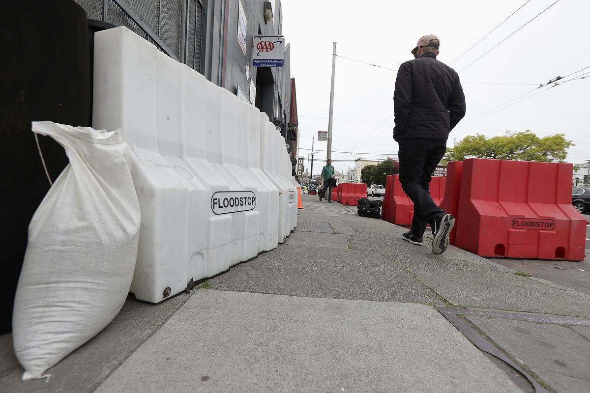 A man walks between flood barriers on 17th Street in San Francisco, Thursday, April 5, 2018. Northern California is bracing for a major spring storm that is expected to dump several inches of rain on burn-scarred areas of wine country. It could also bring the biggest test so far of a partly finished new spillway at the nations tallest dam. (Jeff Chiu / AP)