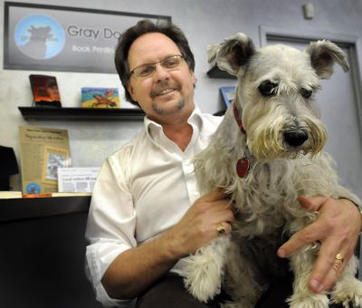 Russ Davis holds his gray dog, Zak, at his printing business, Gray Dog Press, a new publishing house in Spokane. (CHRISTOPHER ANDERSON / The Spokesman-Review)