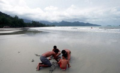 
A group of young tourists plays on a deserted beach on the island of Koh Chang in southern Thailand. 
 (Associated Press / The Spokesman-Review)