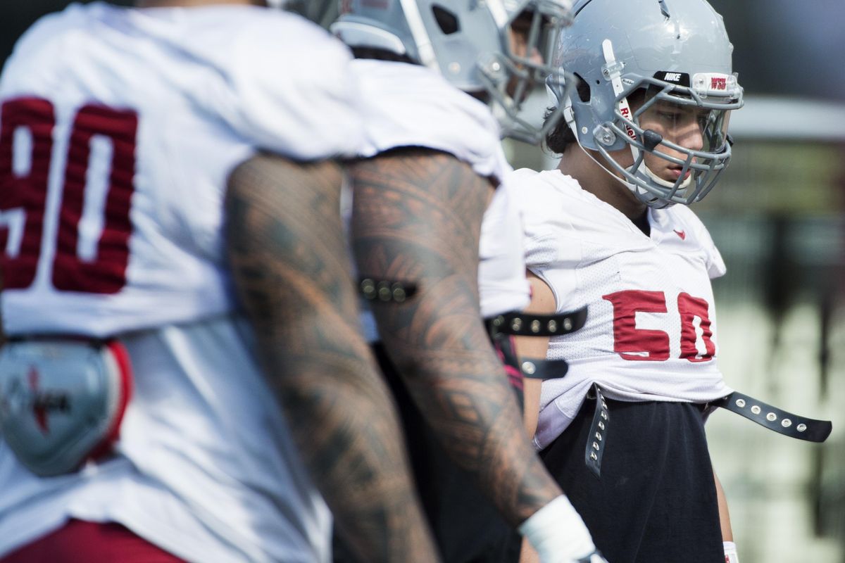 WSU defensive end Hercules Mata’afa, right, listens to defensive coordinator Alex Grinch during a spring practice. (Tyler Tjomsland / The Spokesman-Review)