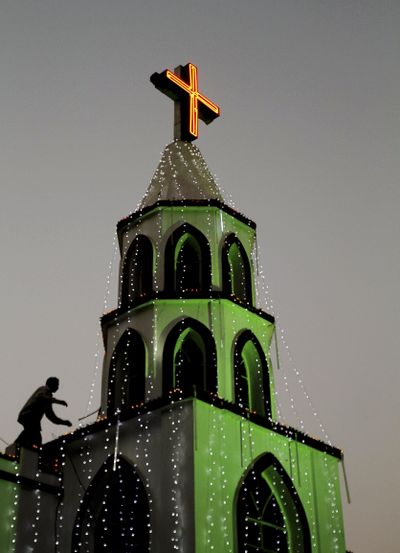 An Indian man decorates a church with lights ahead of Christmas in the eastern Indian city of Bhubaneswar, India, Monday, Dec. 23, 2013. (Biswaranjan Rout / AP)