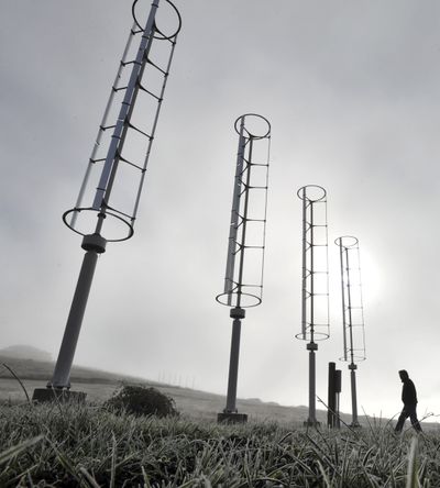 Will Prust walks among wind turbines he has installed on his property near Ashland, Ore., on Dec. 17.  (Associated Press)