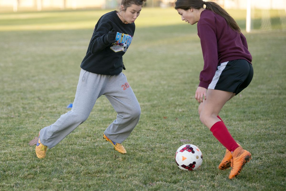 Frankie Schade, left, and Madison Moloney, right, of the West Valley Eagles girls soccer team, practice Monday at Millwood Elementary. (Jesse Tinsley / The Spokesman-Review)