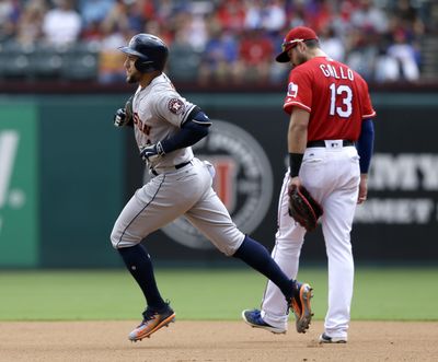 Houston’s George Springer (left) rounds the bases after hitting a solo home run in the fourth inning against Texas on Sunday. (Tony Gutierrez / Associated Press)