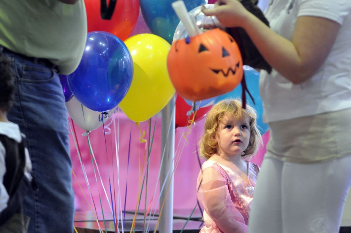 Two-year-old Audrey Lautermilch watches other partygoers enjoy the children’s carnival in the Bank of America Center Saturday morning.   (Jesse Tinsley / The Spokesman-Review)