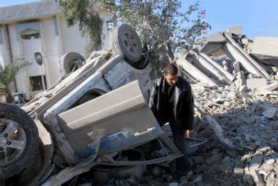 
An Iraqi inspects a police vehicle after a British army raid on  a police station in Basra on Monday. More than 100 prisoners thought to be marked for execution were moved to Iraqi army custody.
 (Associated Press / The Spokesman-Review)