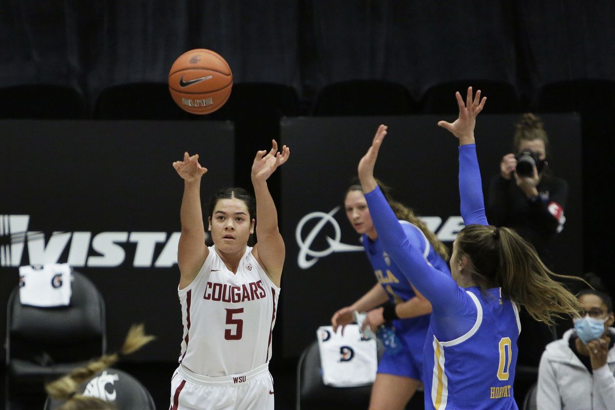 Washington State guard Charlisse Leger-Walker, who scored a game-high 28 points, shoots next to UCLA guard Chantel Horvat, right, during the first half of the Cougars’ win Friday in Pullman.  (Associated Press)