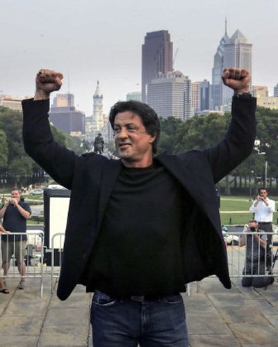 
Actor Sylvester Stallone poses on the top steps of the Philadelphia Museum of Art before the bronze statue of Stallone portraying the boxer Rocky Balboa from the film 