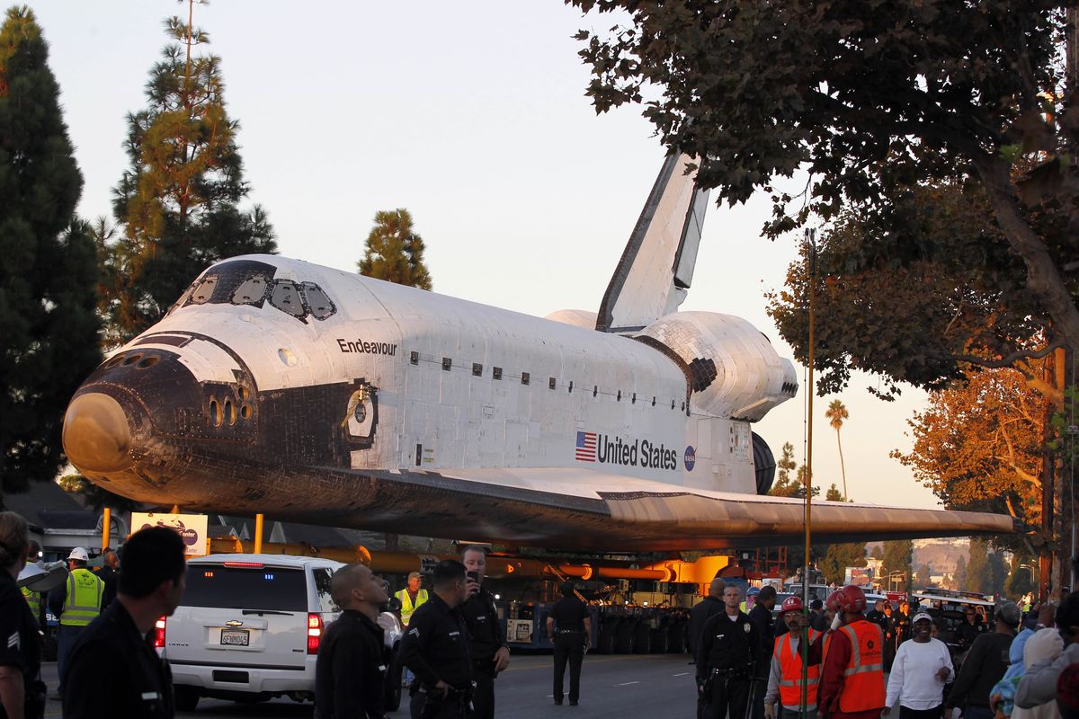 The space shuttle Endeavour slowly moves down Martin Luther King Blvd. in Los Angeles,  Sunday, Oct.14, 2012. In thousands of Earth orbits, the space shuttle Endeavour traveled 123 million miles (198 million kilometers). But the last few miles (kilometers) of its final journey are proving hard to get through. Endeavour
