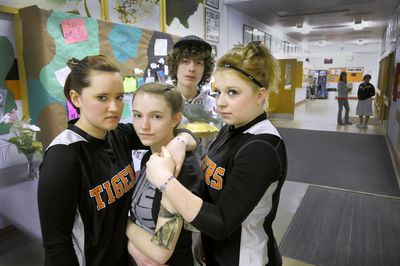 Republic High School  debate team members, from left, Cassandra Novotney, Emily Ann Rice, Dakota Strine and Nicole Dawn Ordway stand Tuesday at a memorial wall for their coach and teacher Dan Walling, who died in a boat crash Friday.  Their bracelets and camo armbands are to honor his memory.  (Christopher Anderson / The Spokesman-Review)