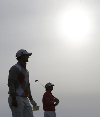 Brandt Snedeker, right, watches his shot from the 16th tee as Adam Scott looks on during the third round. Scott leads by four strokes with second-round leader Snedeker tied for second with Graeme McDowell. (Associated Press)