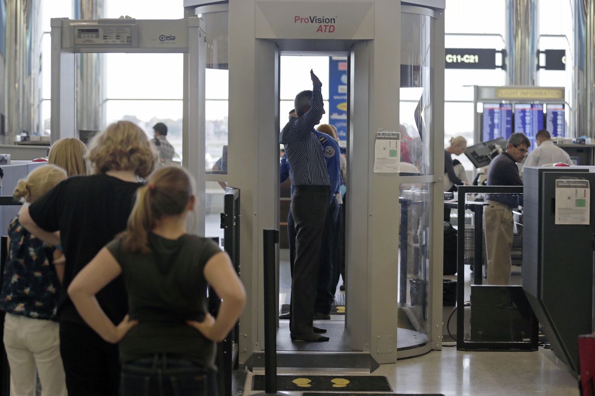 Passengers are scanned at a Terminal C security checkpoint at Logan Airport in Boston using a millimeter wave body scanner on Wednesday. (Associated Press)
