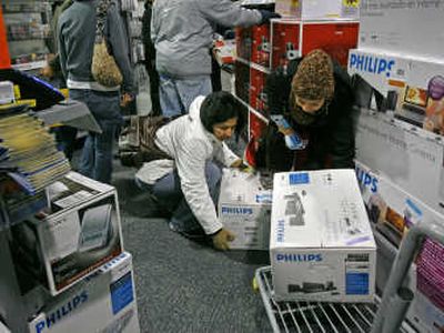 Lorena Salazar, left, and Maria Claudia Ramos  grab home theater units  at a 5 a.m. sale Friday  at a Best Buy in McLean, Va. Associated Press
 (Associated Press / The Spokesman-Review)